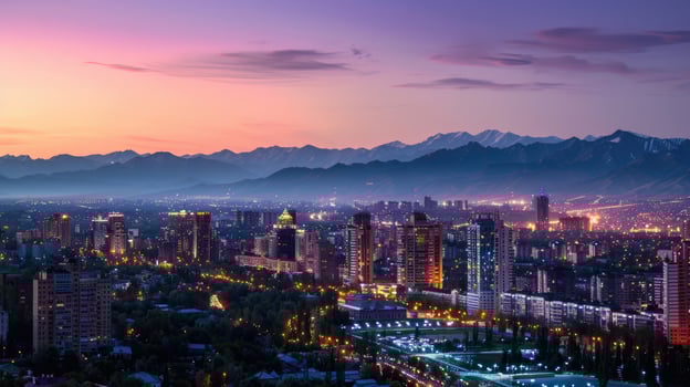 An expansive view of Almaty's cityscape at dusk with vibrant lights and mountains visible. photo