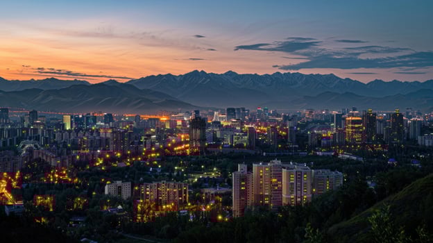 An expansive view of Almaty's cityscape at dusk with vibrant lights and mountains visible. photo