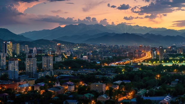 An expansive view of Almaty's cityscape at dusk with vibrant lights and mountains visible. photo