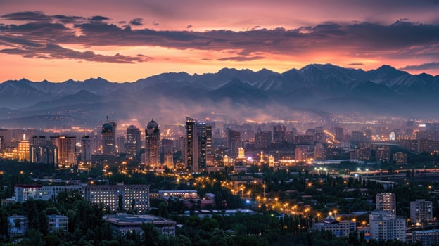 An expansive view of Almaty's cityscape at dusk with vibrant lights and mountains visible. photo