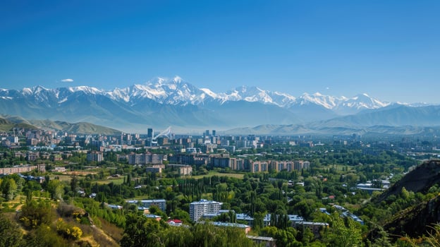 A sweeping view of Almaty with snow-capped mountains in the distance on a bright sunny day. photo