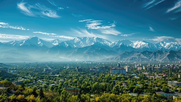 A sweeping view of Almaty with snow-capped mountains in the distance on a bright sunny day. photo