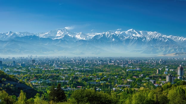 A sweeping view of Almaty with snow-capped mountains in the distance on a bright sunny day. photo
