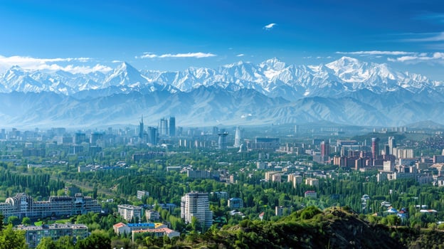 A sweeping view of Almaty with snow-capped mountains in the distance on a bright sunny day. photo