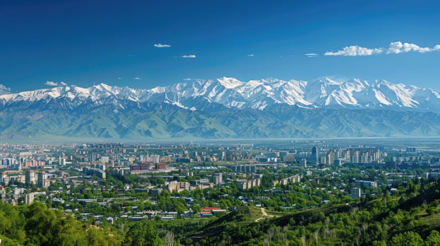 A sweeping view of Almaty with snow-capped mountains in the distance on a bright sunny day. photo