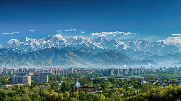 A sweeping view of Almaty with snow-capped mountains in the distance on a bright sunny day. photo