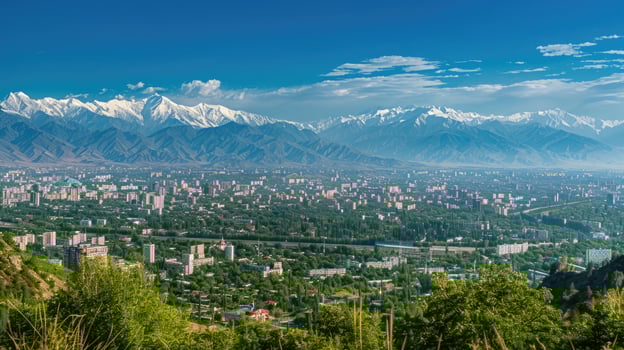 A sweeping view of Almaty with snow-capped mountains in the distance on a bright sunny day. photo