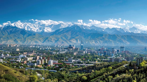 A sweeping view of Almaty with snow-capped mountains in the distance on a bright sunny day. photo