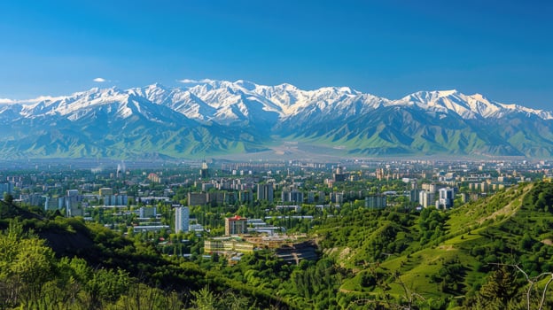 A sweeping view of Almaty with snow-capped mountains in the distance on a bright sunny day. photo