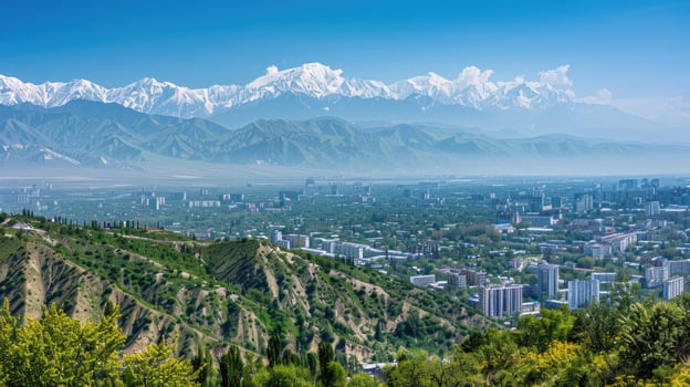 A sweeping view of Almaty with snow-capped mountains in the distance on a bright sunny day. photo