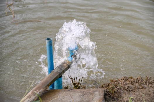 Blue pipe pump rush water falling in pond photo