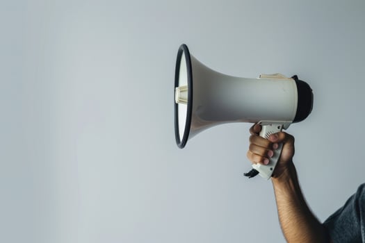 Hand holding a megaphone on a white background photo