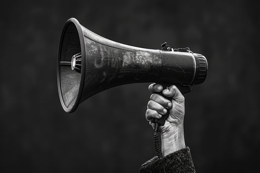 Hand Holding Megaphone Raised in Protest photo