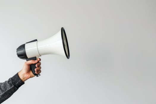 Hand holding a megaphone on a white background photo