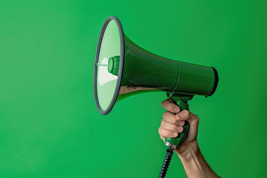 Hand holding a green megaphone against a green background photo