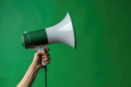 Hand holding a megaphone against a green cracked wall background photo