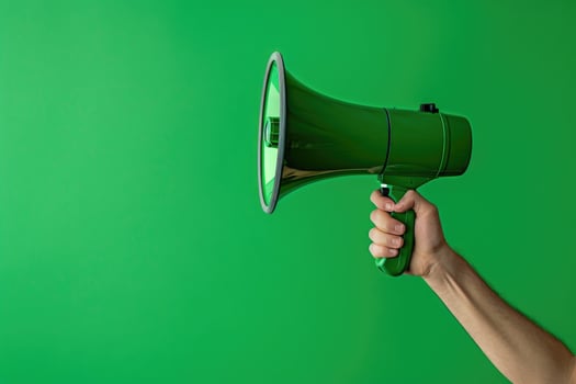 Hand holding a green megaphone on a green background photo