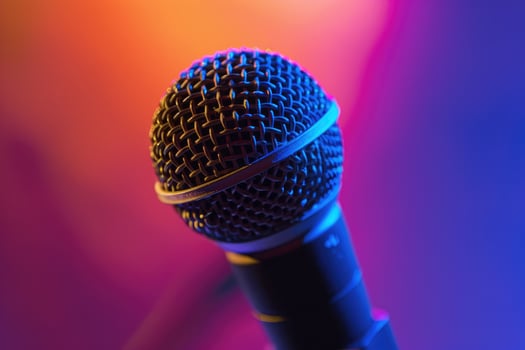 Close up of a microphone on stage with colorful blurred background lights photo
