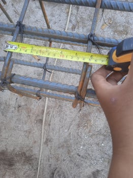 Mature construction worker measuring with tape photo