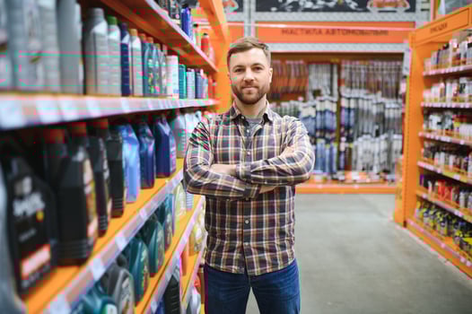 seller man with canister of motor oil in auto store photo