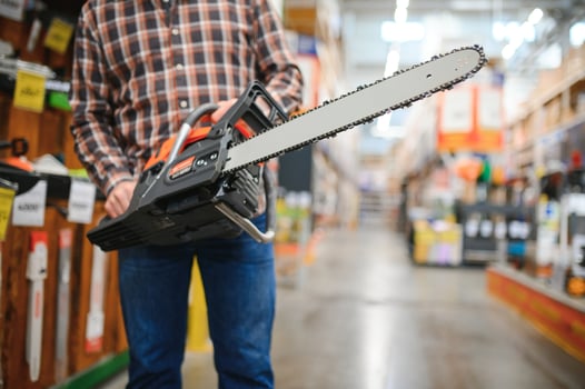 Worke holds electric saw in tool store photo