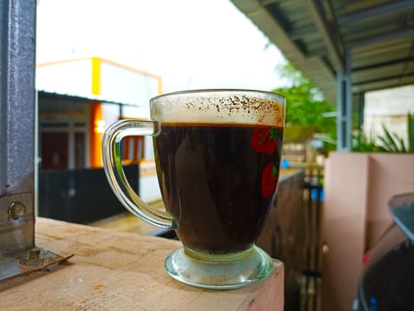 A glass coffee mug with a drink in it photo