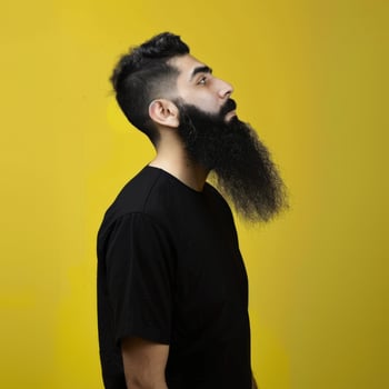 Muslim Man With a Big Beard Posing Against a Yellow Background photo