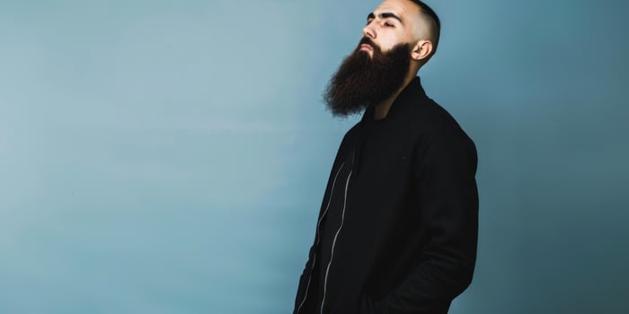 Muslim Man With a Beautiful Beard Posing Against a Blue Background photo