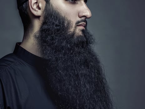 Muslim Man With a Beautiful Beard Posing Against a Dark Background photo
