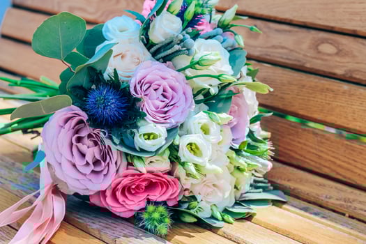 wedding bouquet of purple and beige roses and snow-white lisianthus. Close-up photo