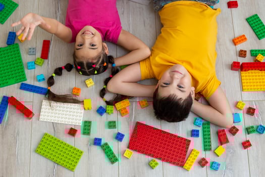 Portrait of happy boy and a little girl, lie on the floor with multicolor constructor photo
