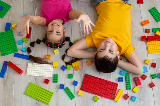 Portrait of happy boy and a little girl, lie on the floor with multicolor constructor photo