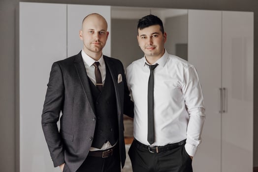 Two men in suits and ties pose for a photo. Scene is professional and formal photo