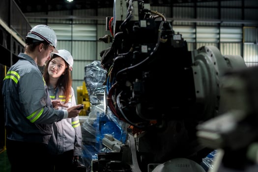 team engineers inspecting on machine with smart tablet. Worker works at heavy machine robot arm. The welding machine with a remote system in an industrial factory. Artificial intelligence concept. photo