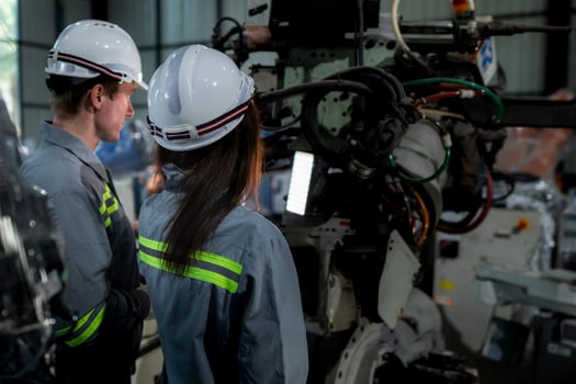 team engineers inspecting on machine with smart tablet. Worker works at heavy machine robot arm. The welding machine with a remote system in an industrial factory. Artificial intelligence concept. photo