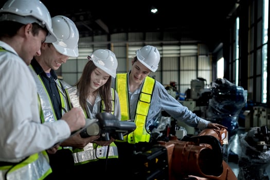team engineers inspecting on machine with smart tablet. Worker works at heavy machine robot arm. The welding machine with a remote system in an industrial factory. Artificial intelligence concept. photo