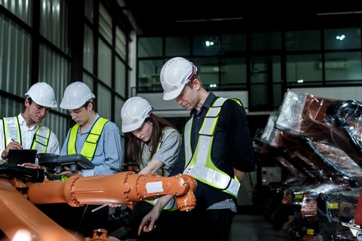 team engineers inspecting on machine with smart tablet. Worker works at heavy machine robot arm. The welding machine with a remote system in an industrial factory. Artificial intelligence concept. photo