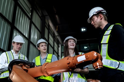 team engineers inspecting on machine with smart tablet. Worker works at heavy machine robot arm. The welding machine with a remote system in an industrial factory. Artificial intelligence concept. photo