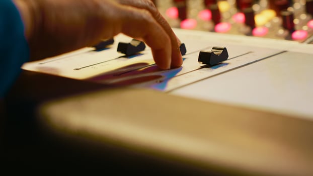 Audio expert recording and editing tracks with mixing console, twisting mixer knobs and changing settings. Sound engineer working in control room to produce music, key buttons. Close up. Camera A. photo