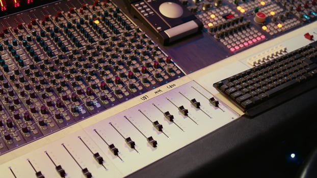 Empty professional studio with control desk mixer and pre amp knobs, music recording and editing with audio software. Control room buttons and sliders in post production, soundproof space. photo