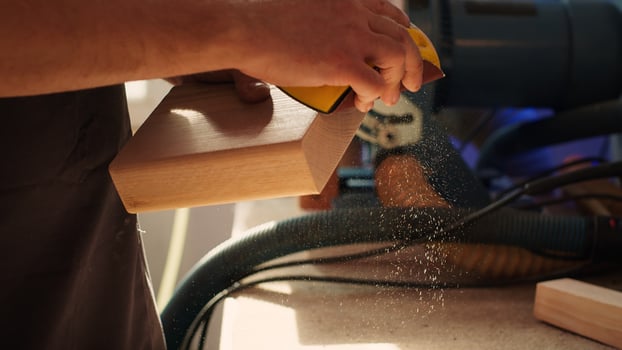 Manufacturer working in joinery using sanding block to remove imperfections on wood piece. Woodworking specialist using coarse grade sandpaper to do manual sanding on lumber, camera A close up photo
