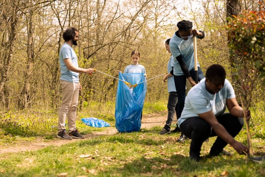 People collaborating to use proper tools and clean the forest, recycling plastic waste and fighting pollution. Activists team volunteering to collect rubbish from the woodland ecosystem. photo