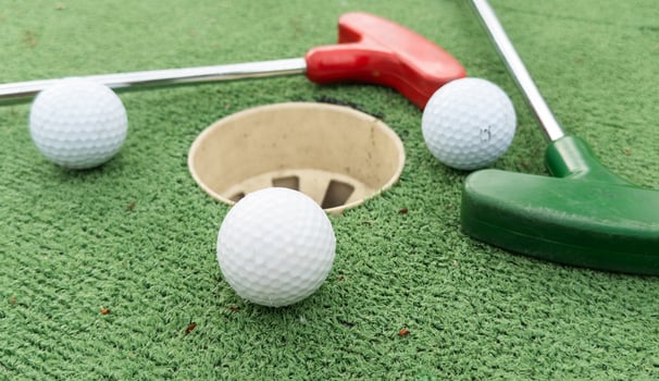 Mini golf close-up, colorful golf putters, balls photo