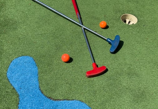 Golf stick and ball on green grass close up. photo