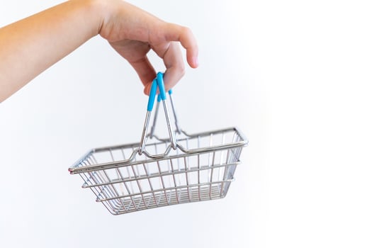 Kids hand carries Small shopping basket on white background. It is a symbol of online shopping. photo