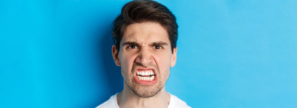 Headshot of angry caucasian man looking with scorn and dismay, being mad at person, standing against blue background photo