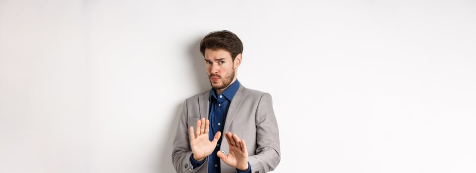 Stay away. Reluctant businessman step back with concerned disgusted face, raising hands to block bad offer, rejecting something awful, telling no and decline proposal, white background photo