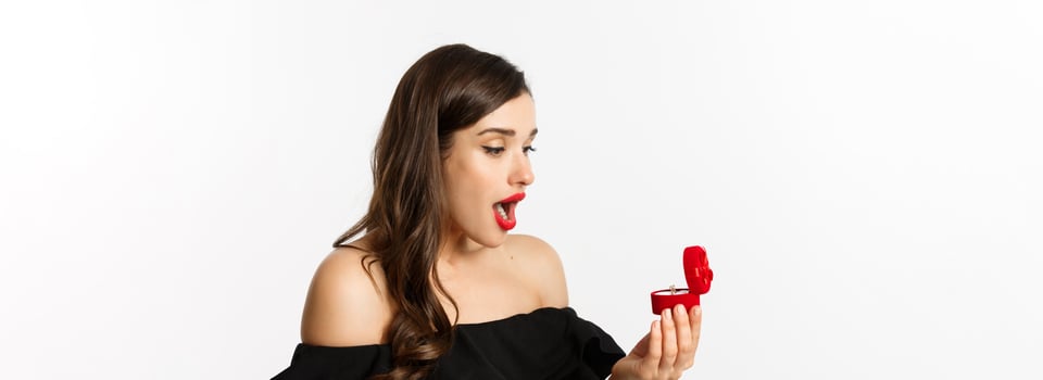 Close-up of surprised woman open box with engagement ring, looking amazed, receiving marriage proposal, girlfriend getting married photo