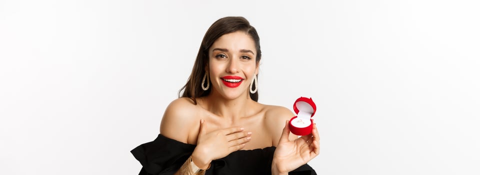 Close-up of happy woman showing her engagement ring, receive marriage proposal, saying yes, standing over white background photo