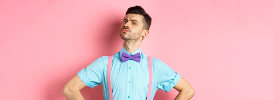 Proud and confident caucasian guy with moustache and bow-tie, looking arrogant with chin up, frowning and looking at camera, standing on pink background photo